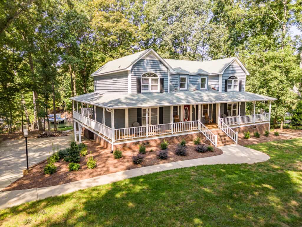 a large house with a lawn and trees