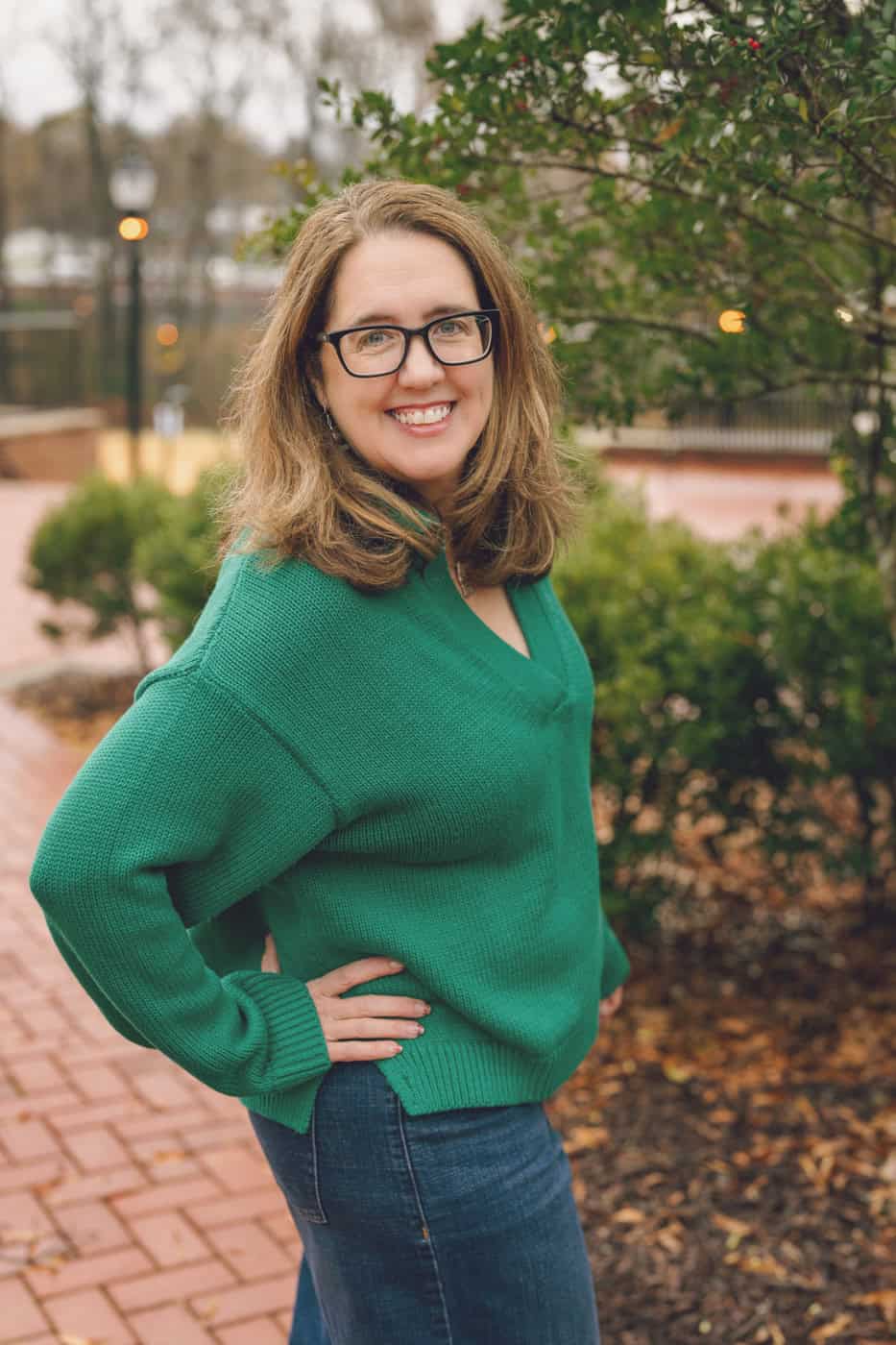 a woman wearing glasses and a green sweater