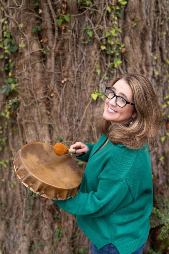 a woman in glasses playing a drum