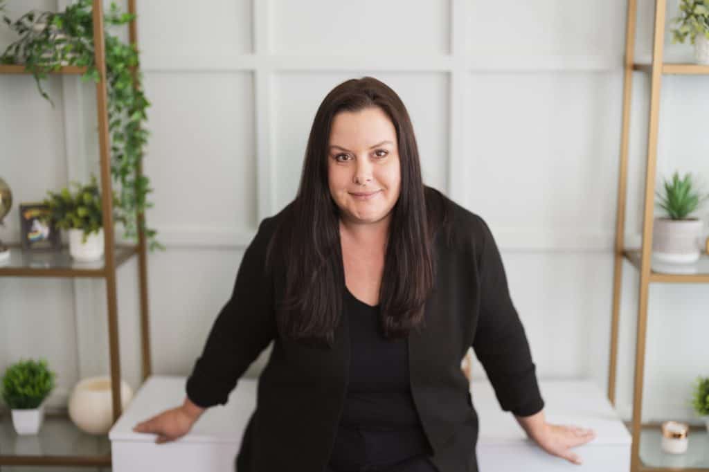 a woman in black sitting on a white surface - Why Introverts Thrive as Entrepreneurs