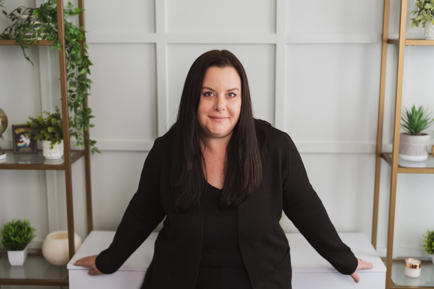 a woman in black sitting on a white surface
