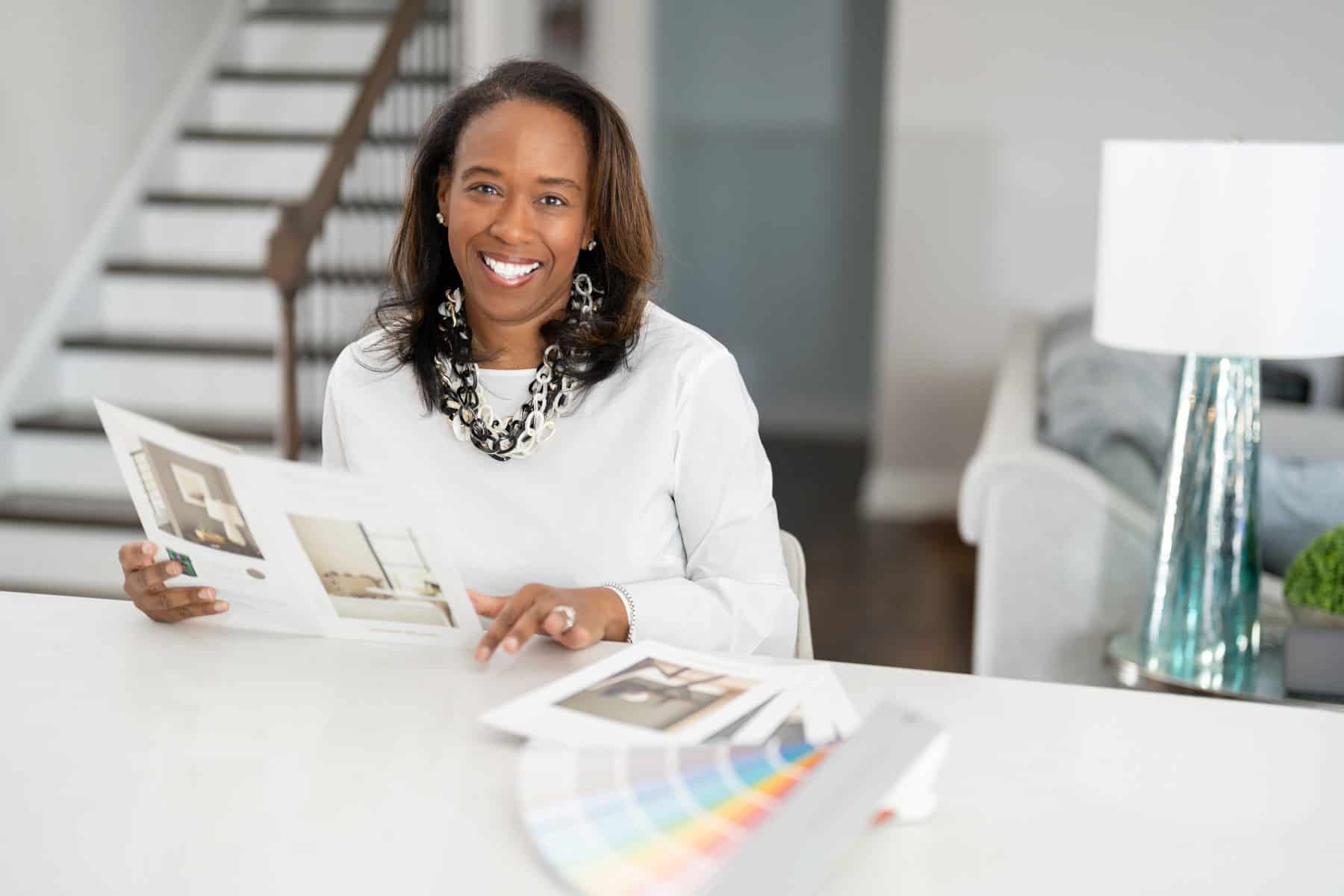a woman smiling at a table with a catalog