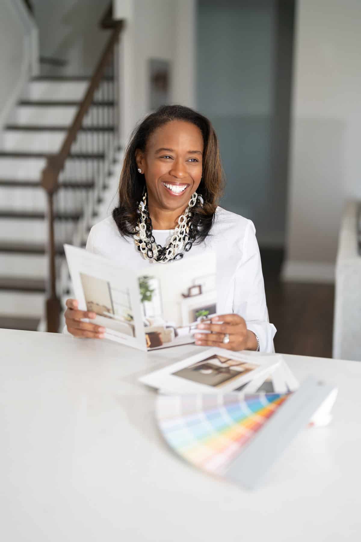 a woman smiling at a table with a book