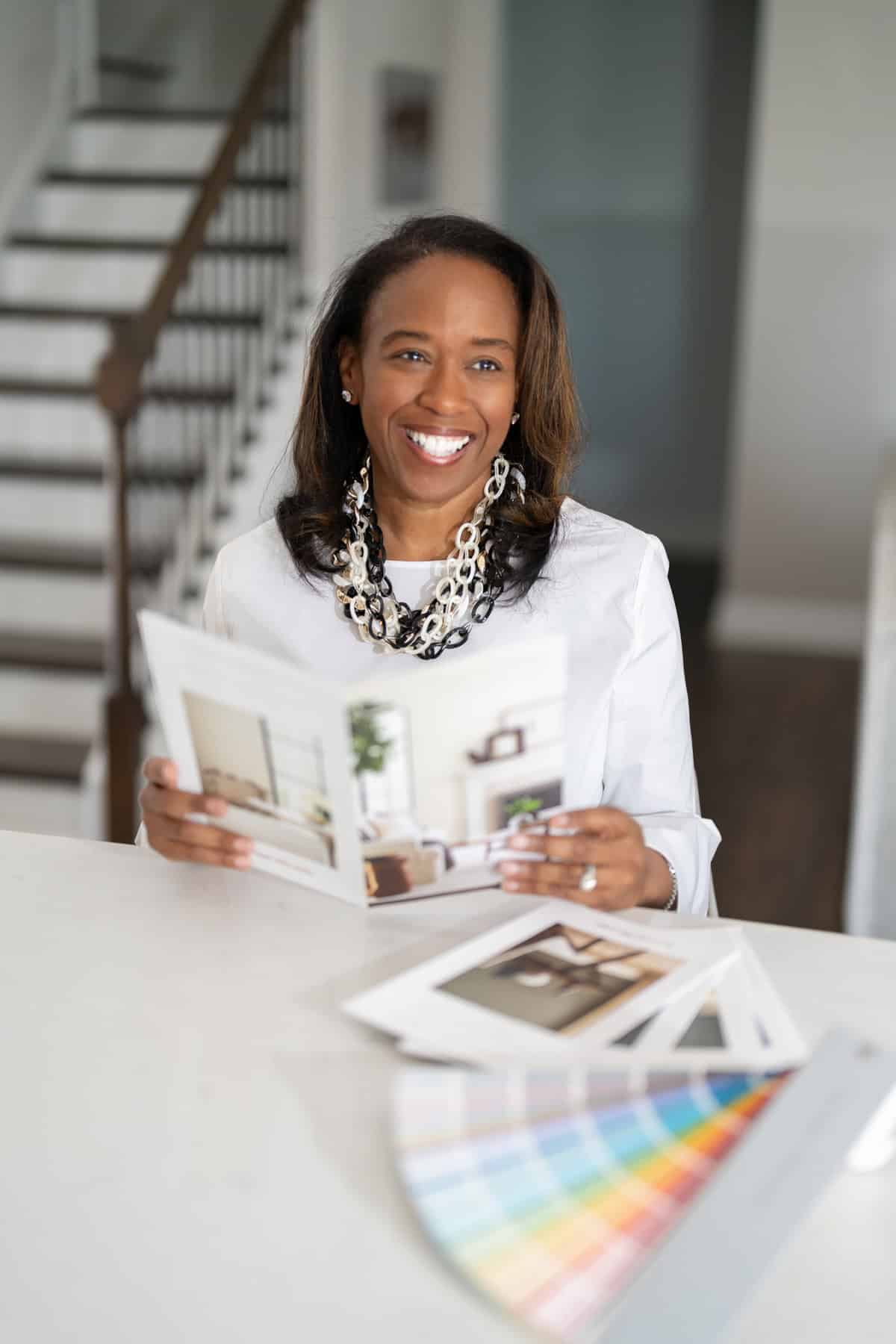 a woman smiling at a table with a catalog
