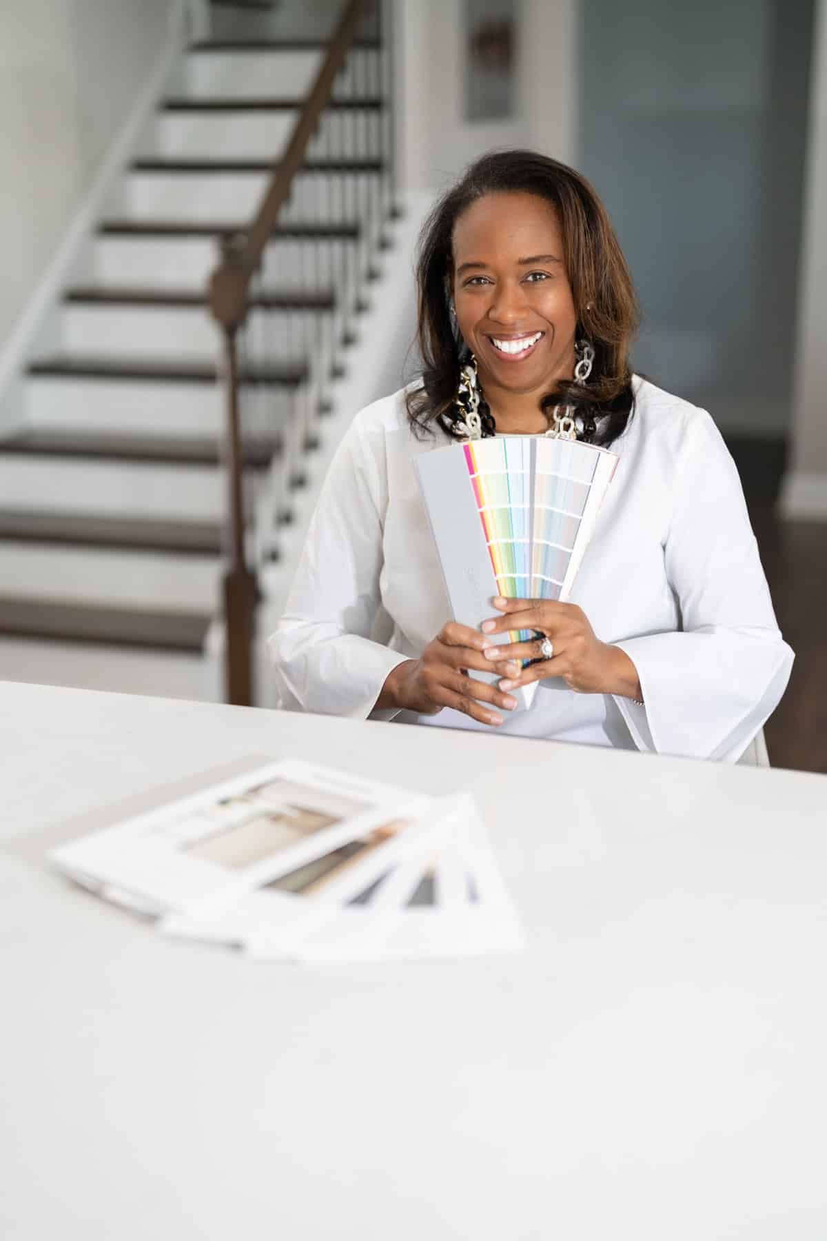 a woman holding a fan of color swatches