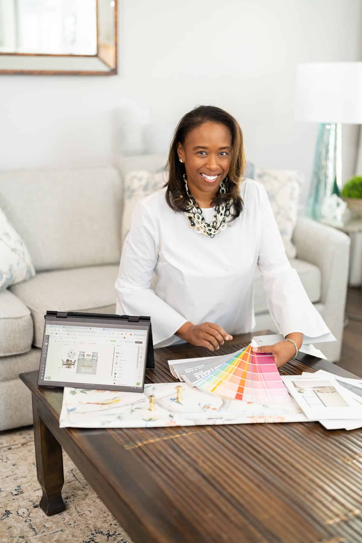 a woman sitting at a table with a color swatch