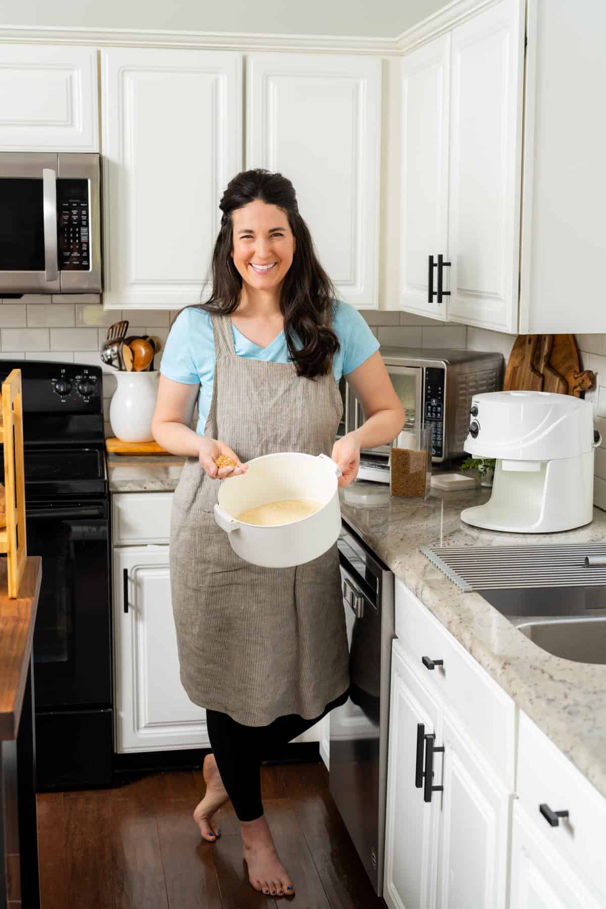 a woman in a kitchen holding a bowl of food